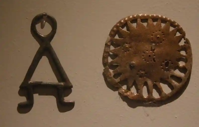 Bronze solar disc with circle dot forming a cross in the center